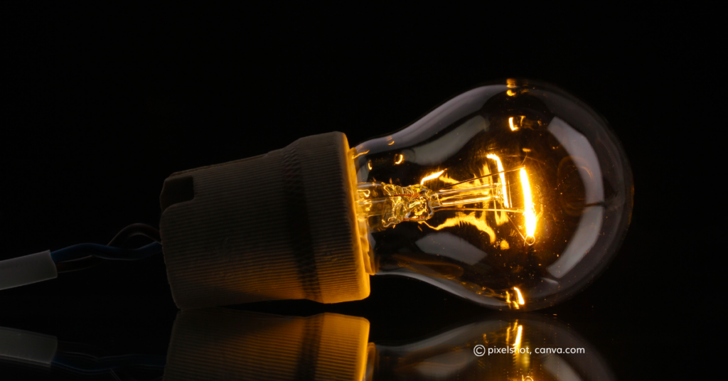 A lightbulb on its side against a black background, by pixelshot, canva.com