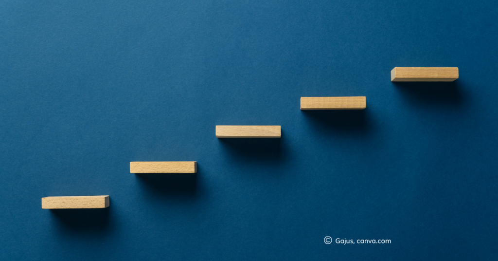 Floating wooden steps on a blue wall, by Gajus, canva.com